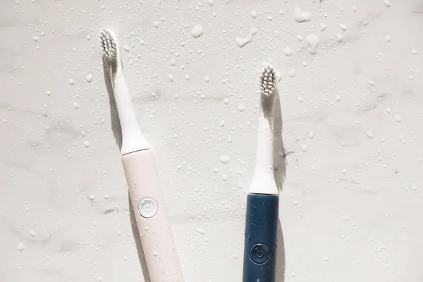 New modern ultrasonic toothbrush with splashes and drops of water on marble background. Oral hygiene, dental and gum health, healthy teeth. Dental products Ultrasonic vibration toothbrush. — Stock Photo, Image