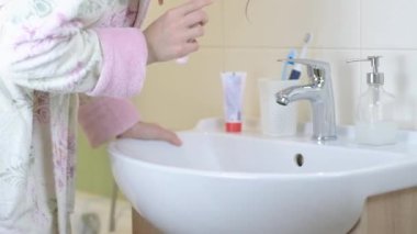 Kadın yeni ultrasonik elektrikli diş fırçası kullanıyor. Profesyonel ağız bakımı kavramı ve sağlıklı dişler. Sonik akıllı diş fırçası kullanarak. Günlük hayat ve rutin.