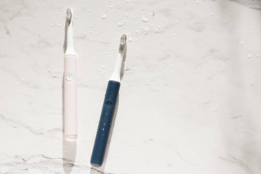 Yeni modern ultrasonik diş fırçası mermer zemin üzerinde su damlaları var. Ağız temizliği, diş ve diş sağlığı, sağlıklı dişler. Diş ürünleri Ultrasonik titreşim diş fırçası.