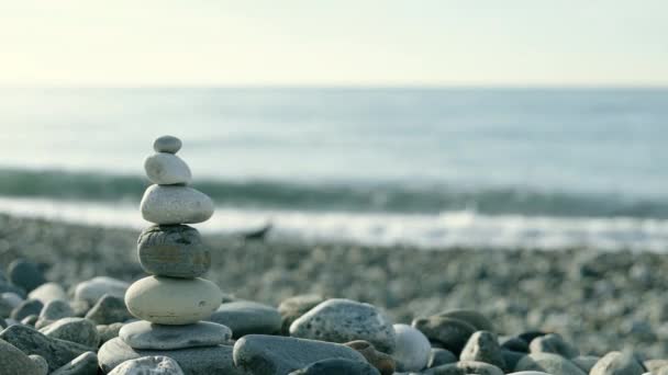 Zen pyramid of balanced stones on a background of the sea and blue sky. Concept of spiritual harmony, balance and meditation. Peace and love in world — Vídeo de Stock