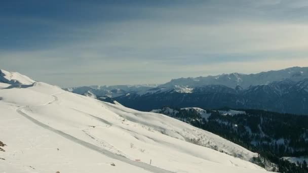 Téli hegyek panoráma sípályák és felvonók egy napsütéses napon. Síközpont, lift, hegyek széles panoráma háttér — Stock videók