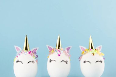 Easter unicorn eggs isolated on blue background. Happy easter banner. Kids activity inspiration. Greeting card or poster. Copy space for text