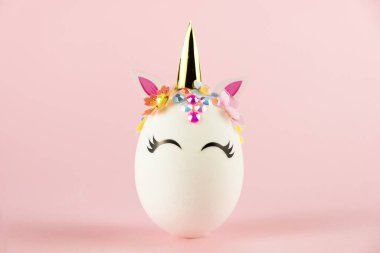 Easter unicorn egg isolated on pink background. Happy easter banner. Kids activity inspiration. Greeting card or poster. Copy space for text