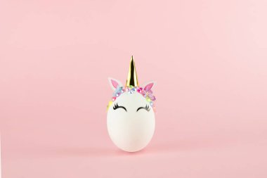 Easter unicorn egg isolated on pink background. Happy easter banner. Kids activity inspiration. Greeting card or poster. Copy space for text