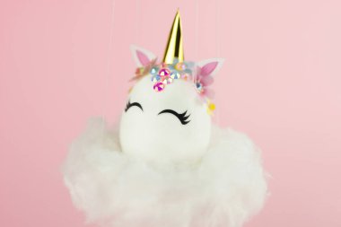 Easter unicorn egg flying on cloud on pastel pink background. Happy easter banner. Kids activity inspiration. Greeting card or poster. Copy space for text. Levitation egg