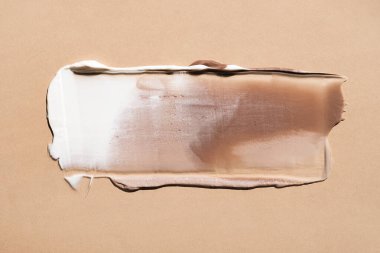 White cream texture on a pastel beige background. Cosmetic mask balm gel. Smears of foundation for the face