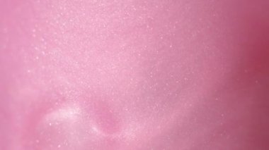 Glittering abstract pink background. Color fluid is swirling in beautiful silver clouds. Glitter dust is moving slowly in water. Amazing abstract texture background.