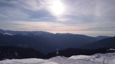 Mavi gökyüzünün altındaki Soçi 'deki kar dağı manzarasının havadan görünüşü. Kış insansız hava aracı görüntüleri zirvede. Destansı Panorama Doğa. Güzel Dağ Sıraları Kış İlham verici Manzara