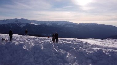 Kar dağlarında bir çift. Soçi 'deki kar dağı manzarasının mavi gökyüzünün altında arka planda bulutlar var. Kış İHA görüntüleri
