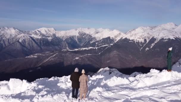 Couple dans les montagnes de neige. Vue aérienne du paysage de la chaîne de montagnes de neige à Sotchi sous le ciel bleu avec des nuages en arrière-plan. Images de drone d'hiver — Video