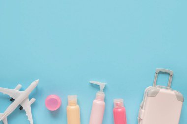 Airport rules instruction before boarding the aircraft. Liquid with carry on baggage. Travel accessories on blue background. Luggage. Prepared for the trip. Summer travel concept.