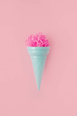 Pink paper ice cream scoop with ice cream plastic cone on bright pink background. Minimal summer concept. Micro plastic in food. Recycling