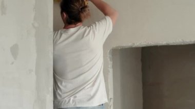 Yenileme dairesi. Elektrik tesisatı. Boş duvarlar, kendi elleriyle tamir ettikleri ev. Elektrikçi evin içine kerpetenle elektrik kabloları yerleştiriyor.. 