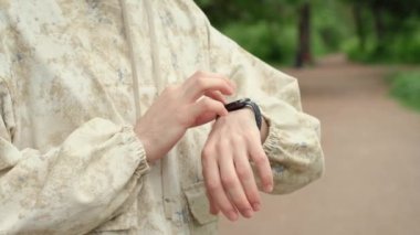 Smart watch on a mans hand. Man touching a smart tracker band screen, checking heart rate and pulse before training. Summer outdoor activities. High quality FullHD footage