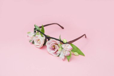 Summer concept of beach sunglasses with flowers instead of glasses on a pink background. Summer vacation and enjoyment minimal concept. Woman accesory