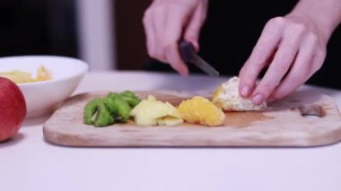 Turuncuyu dilimlere ayır. Meyve salatası hazırlanıyor. 