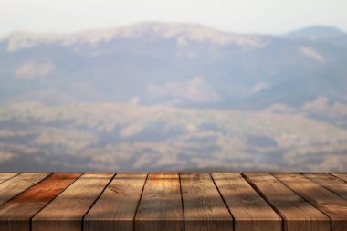 Dağların bulanık arkaplanındaki boş tahta 