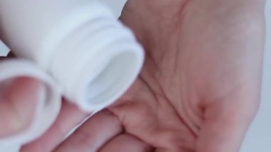 Bir kadın eline çinko tablet döküyor. Haplar yakın plan. Sağlıklı konsept. 