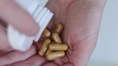 Kadın eline C vitamini kapsülleri döküyor. Kapsüller yakın plan. Diyet yemek ve sağlıklı konsept. Tabletler ve diyet takviyeleri