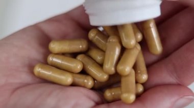 Kadın eline C vitamini kapsülleri döküyor. Kapsüller yakın plan. Diyet yemek ve sağlıklı konsept. Tabletler ve diyet takviyeleri