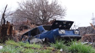 Ukrayna, Borodyanka - 04.21.2022: Rezidans binalarından arta kalan harabelere karşı bozuk bir araba. Rusya 'nın Ukrayna' ya yaptığı saldırıların sonuçları