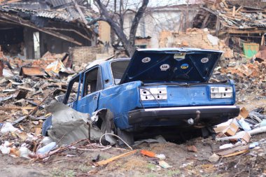 Ukrayna, Borodyanka - 04.21.2022: Rezidans binalarından arta kalan harabelere karşı bozuk bir araba. Rusya 'nın Ukrayna' ya yaptığı saldırıların sonuçları