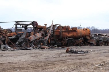 Ukrayna, Bucha - 04.21.2022: Kırık askeri teçhizat, ateş edilen arabalar, buruşmuş metal ve pas mezarlığı