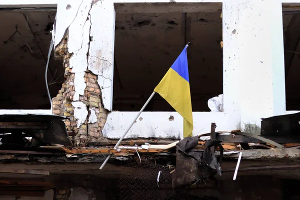 Ukrayna, Borodyanka - 04.21.2022: Bir binanın harabelerinde Ukrayna bayrağı serildi. Ukrayna 'daki Rus birliklerinin işgali ve bunun sonuçları. Sembol