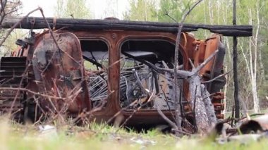 Ukrayna, Dmytrivka, Kyiv Oblastı - 04.26.2022: Yol kenarındaki ormanın kenarında yanmış Rus piyade aracı. Rusya 'nın Ukrayna' yı işgalinin sonuçları 2022. 