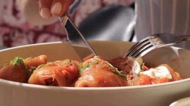 Lahana rulolarının olduğu bir kaseyi kapat. Lokantada yemek, kes ve bir parça al. Lezzetli.