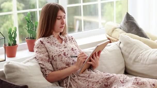 Dziewczyna Pisze Notatniku Siedząc Kanapie Przytulnym Wnętrzu Zdalne Uczenie Się — Wideo stockowe