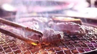 Korean barbecue. Barbecue in a restaurant, roasting meat at the table. Cooking on coals. Roasting meat close-up, steam