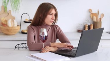 Mutfakta dizüstü bilgisayarı olan bir iş kızı, internetten materyal okuyor. Serbest çalışmak, online alışveriş yapmak ya da internette sörf yapmak