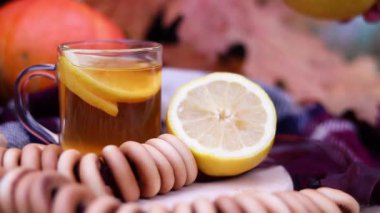 Sonbahar kompozisyonu koleksiyonu, limonlu çay. El, çay fincanının yanına tarçın ve limon koyar.