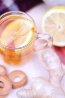 Limonlu, zencefilli ve simitli bir fincan çay. Sonbahar kompozisyonu, piknik. Sonbaharda sıcak içecek, nesnelerin seçici odak noktası