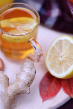 Limonlu bir fincan çay, zencefil. Sonbahar kompozisyonu, piknik. Sonbaharda sıcak içecek, nesnelerin seçici odak noktası