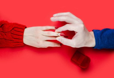 Adam bir kızın parmağına yüzük takıyor. Evlilik teklifi. Yakın plan. Üst görünüm.