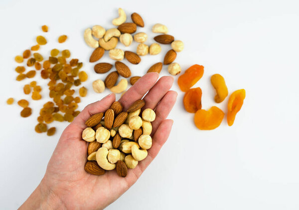 Woman's hand holding a mix of nuts. Healthy food concept. Copy space. Close-up. Selective focus.