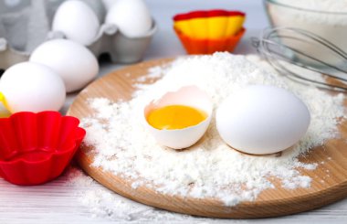 Kek ve kek pişirmek için gereken malzemeler: un, yumurta ve renkli silikon form. Yakın plan..