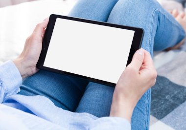 Kadının elleri beyaz ekranlı dijital tablet tableti tutuyor. Tablet boş ekran modeli. Yakın plan. Boşluğu kopyala.
