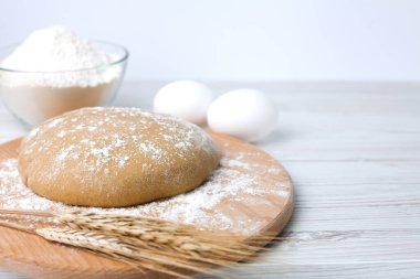 Hazırlanması için hamur ve malzemeler: beyaz ahşap zemin üzerinde un ve yumurta. Yakın plan. Boşluğu kopyala.