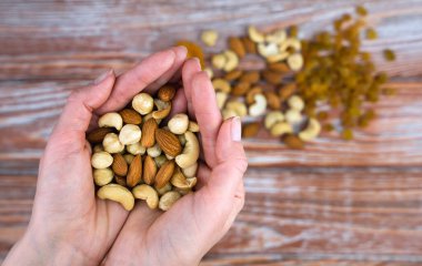 Kadının ellerinde fındık karışımı var. Sağlıklı gıda konsepti. Mesaj için yer. Yakın plan. Seçici odak.