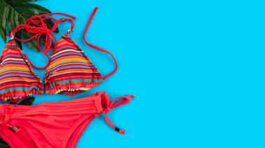 Mavi arka planda kırmızı kadın mayosu. Yaz tatili kavramı. Düz yatıyordu. Üst Manzara. Boşluğu kopyala.