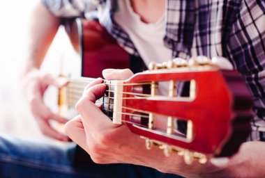Gitar çalan genç adamın elleri. Gitar dersi konsepti. Yakın çekim..