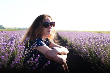 Lavanta tarlasında güneş gözlüklü siyah saçlı genç kız. Yaz güneşli bir gün. Yakın plan. Boşluğu kopyala.