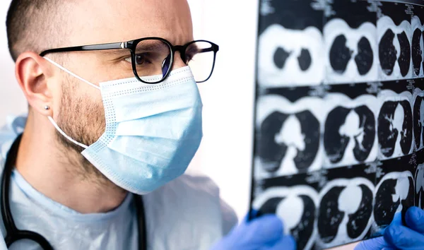 The doctor surgeon examines the x-ray of the patient\'s lungs before the operation. Medicine, diagnostics, treatment. Close-up.