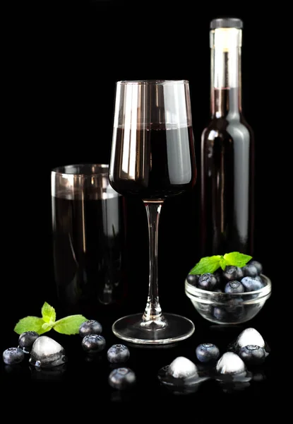 Wine and juice from fresh ripe berries isolated on a black background. The concept of making juice and wine from fresh berries. Close-up. Selective focus.