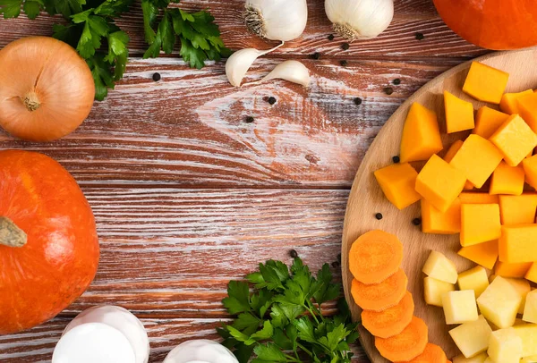 Ahşap mutfak masasında balkabağı çorbası yapmak için sebzeler. Üst Manzara. Metin için yer.