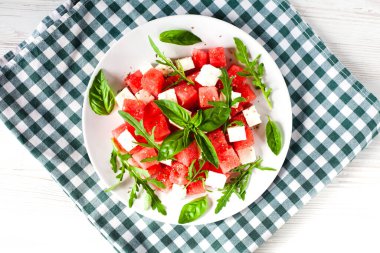 Taze salata, karpuz, peynir roka ve beyaz tabakta fesleğen. Yakın plan. Üst Manzara. Sağlıklı gıda konsepti.