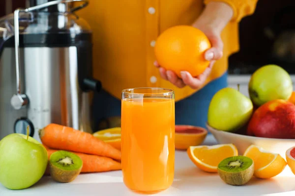 Freshly squeezed multivitamin fruit juice in a glass on the table in the kitchen. Close-up. Selective focus.